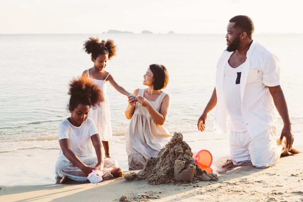 Diversity family playing sand at the beach